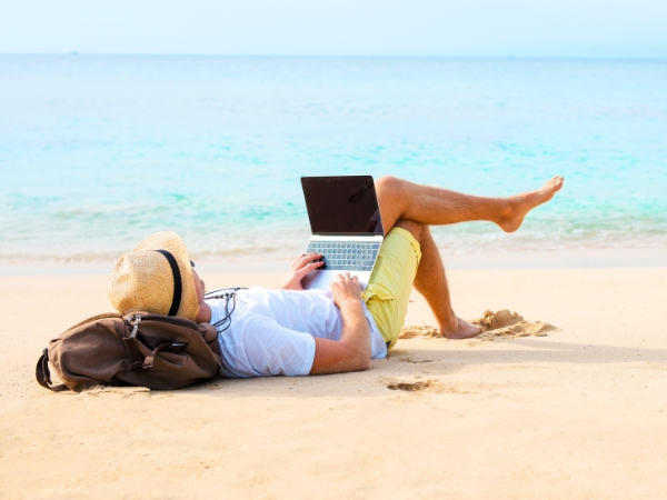 Man Using a Laptop on a Beach